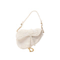 White Christian Dior Saddle canvas shoulder bag with frayed-edge detailing, tonal Christian Dior lettering, white strap and gold-tone D charm.