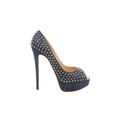 Side view of a Christian Louboutin navy denim pump with silver-tone spike studs, an open toe, raised platform, slim stiletto heel and visible red sole.