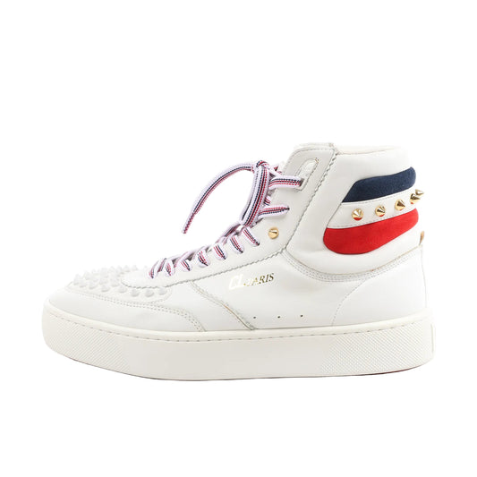 Side view of a white Christian Louboutin leather high-top sneaker in size 42.5 EU, featuring spiked toe detailing, red-white-blue laces, tricolor suede heel panels, and gold-tone studs on a white rubber sole.