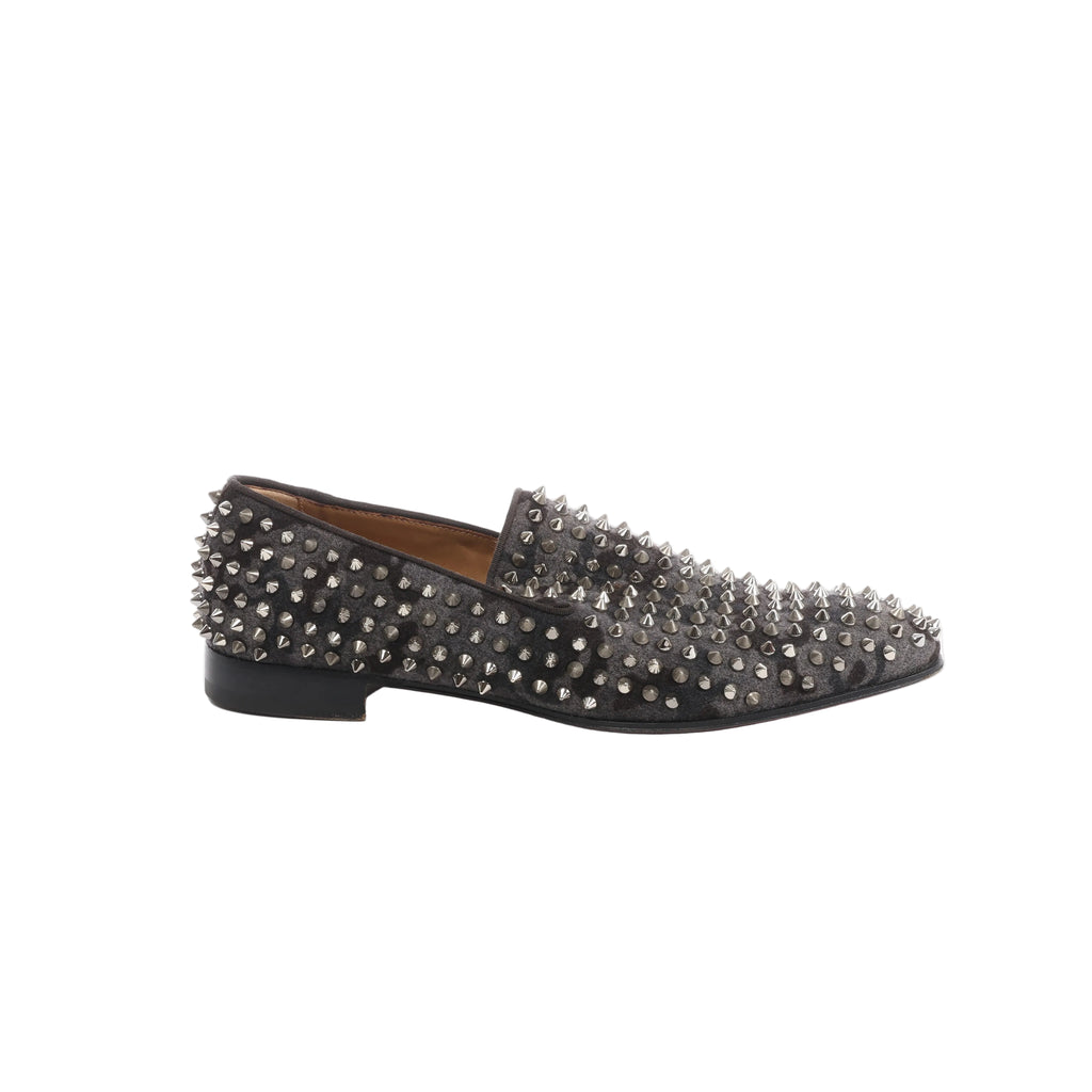 Side view of Christian Louboutin gray and black camouflage loafers with silver-tone spike studs, black trim and a low black heel.