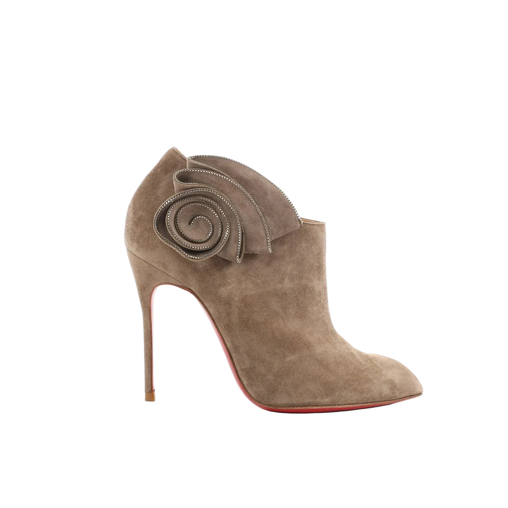 Christian Louboutin taupe suede Mrs Baba 100 bootie with spiral ruffle ankle detail, pointed toe, stiletto heel, and red sole on white background
