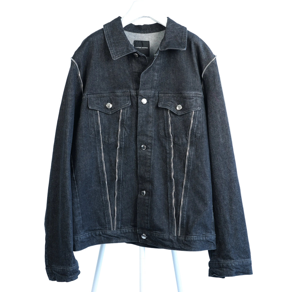 CoSTUME NATIONAL dark denim jacket with silver-tone buttons, contrast vertical stitching, flap chest pockets, and classic collar, displayed on a white hanger.