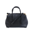 Front view of a black Coach 1941 Cooper Carryall leather handbag with dual top handles, shoulder strap, metal corner accents and a hanging leather tag.