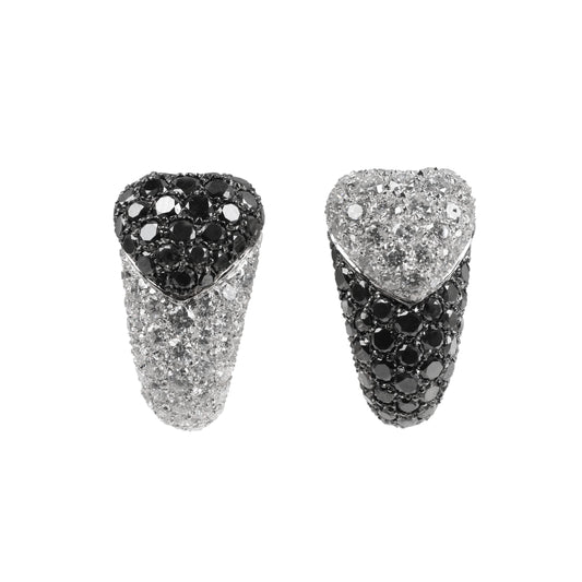 De Grisogono heart-shaped earrings in white gold, featuring a striking combination of white and black pave-set diamonds in an asymmetrical design, displayed against a white background.