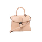 Front view of Delvaux Brillant MM pale pink leather handbag with a curved flap, dark metallic buckle, rounded top handle and matching shoulder strap.