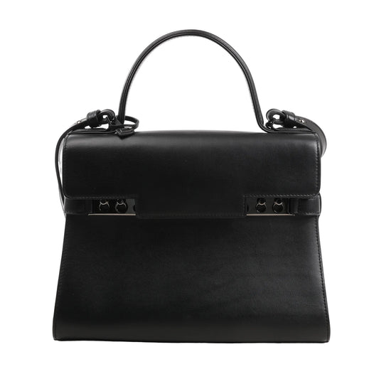 Delvaux Tempête MM 2Way handbag in black smooth leather featuring a structured silhouette, top handle, detachable shoulder strap, and signature studded metal bar closure.
