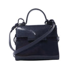 Front view of Delvaux Tempête Mini bag in glossy navy patent leather with top handle, adjustable shoulder strap, flap front, and riveted strap-style detailing.