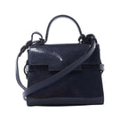 Front view of Delvaux Tempête Mini bag in glossy navy patent leather with top handle, adjustable shoulder strap, flap front, and riveted strap-style detailing.