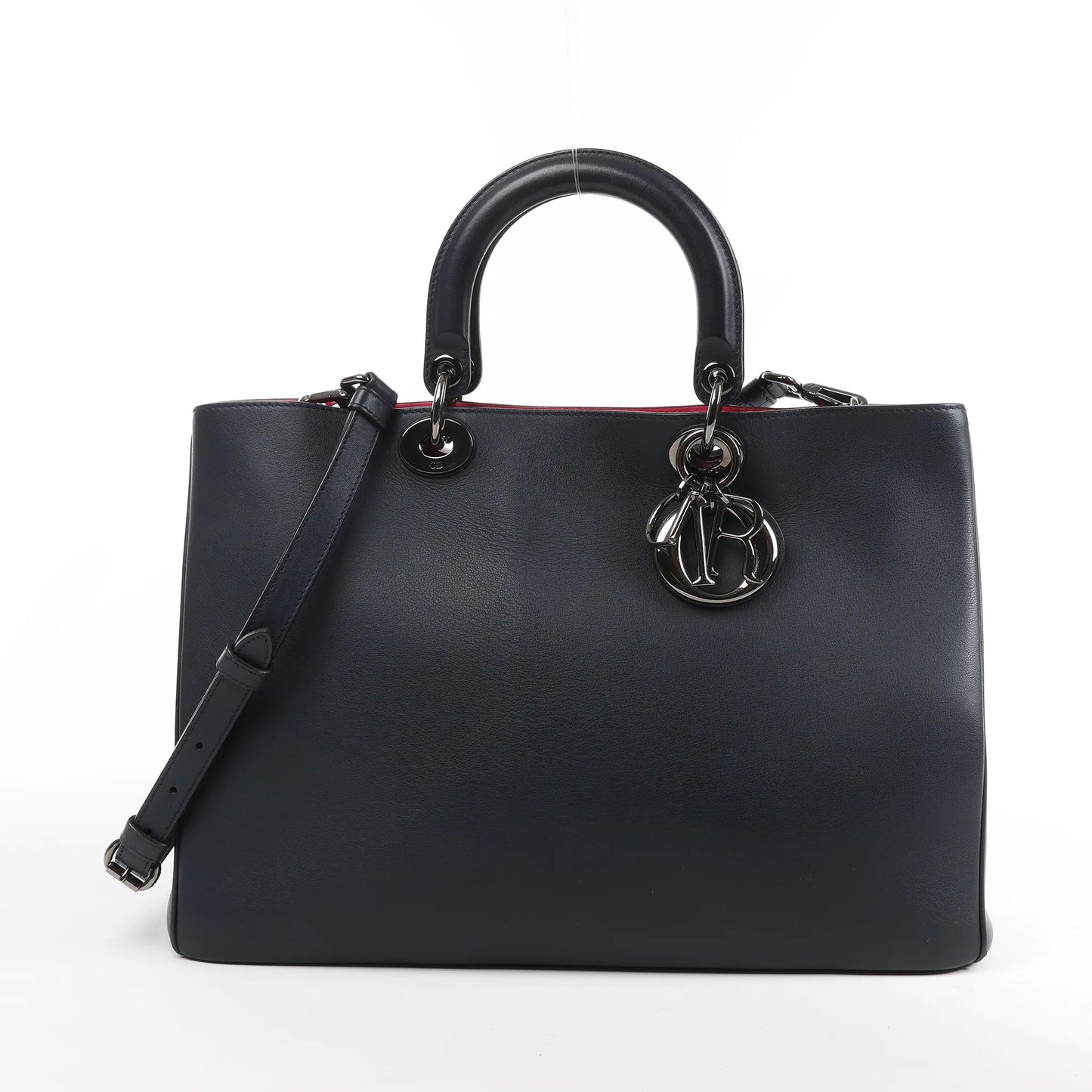 Front view of a Dior Diorissimo Large 2Way Handbag in black smooth leather with pink Rose Indien lining, featuring dual top handles, an adjustable shoulder strap, and silver-tone “D.I.O.R.” charms on a white background.