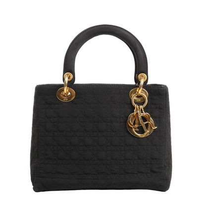 Dior Lady Dior handbag in black cannage-quilted nylon featuring structured top handles, gold-tone hardware, and hanging 'D.I.O.R.' letter charms for a timeless, elegant look.