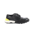 Black Dior leather derby shoe with lace-up front and chunky black lug sole with white midsole and neon yellow heel accent on white background