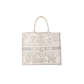 Dior Book Tote Large in gray toile Jouy embroidered canvas with top handles and “CHRISTIAN DIOR PARIS” logo band on the front.