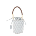 Woven leather mini top-handle bag with gray drawstring pouch closure, braided brown handle, gold-tone rings, and hanging round logo tag