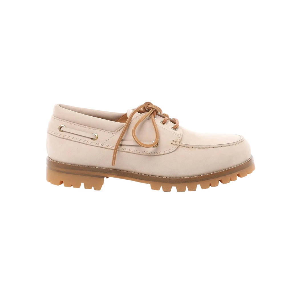 Beige leather lace-up shoe with moc-toe stitching, metal eyelets, tan laces, and tan Vibram lug sole, side profile