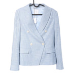Eleventy double-breasted wool blazer in light blue featuring a textured fabric, notch lapels, four light-colored buttons, flap pockets, and light blue lining, displayed on a hanger against a white background.
