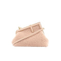 Pink Fendi First crossbody bag with fluffy boa body, structured leather frame top, gold-tone hardware, and a slim detachable shoulder strap.