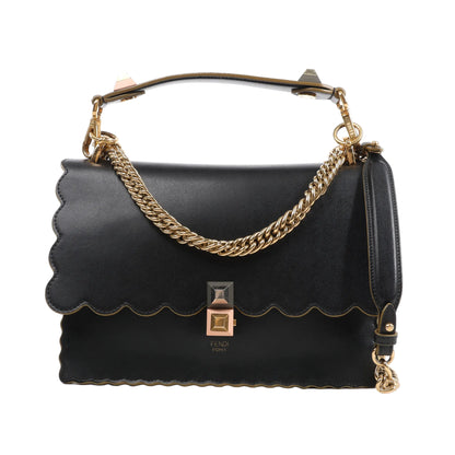 FENDI Kan I 2Way Handbag 8BT283 in black leather with scalloped edges, gold-tone chain and leather strap, and a signature pyramid stud clasp, displayed against a white background.