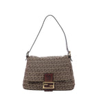 Fendi Mamma Baguette shoulder bag in brown Zucchino canvas with dark leather trim, slim shoulder strap, flap front, and gold-tone FF buckle on white background.