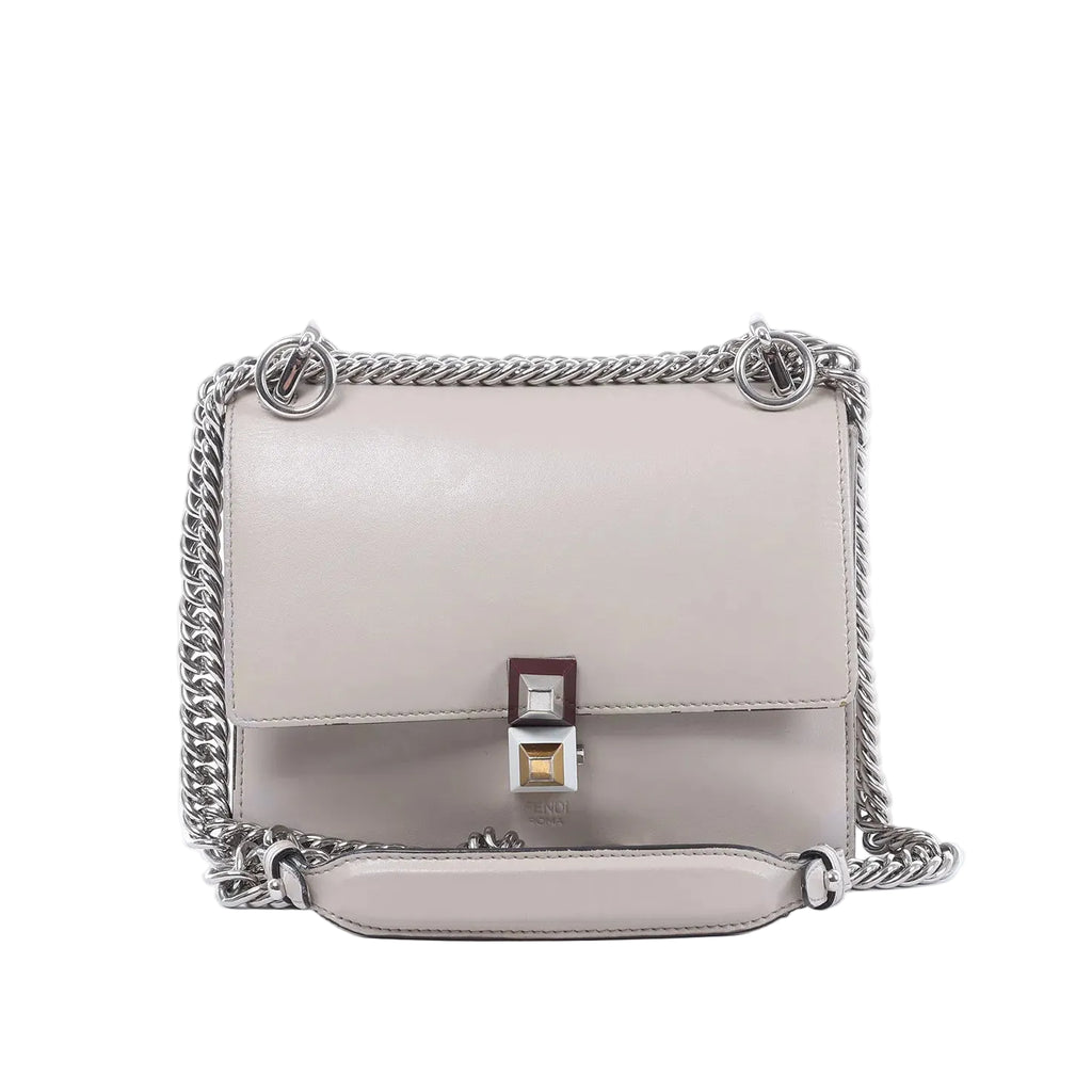Fendi Kan I Mini gray leather crossbody bag with flap front, silver-tone chain strap, leather shoulder pad, and square clasp detail on white background.