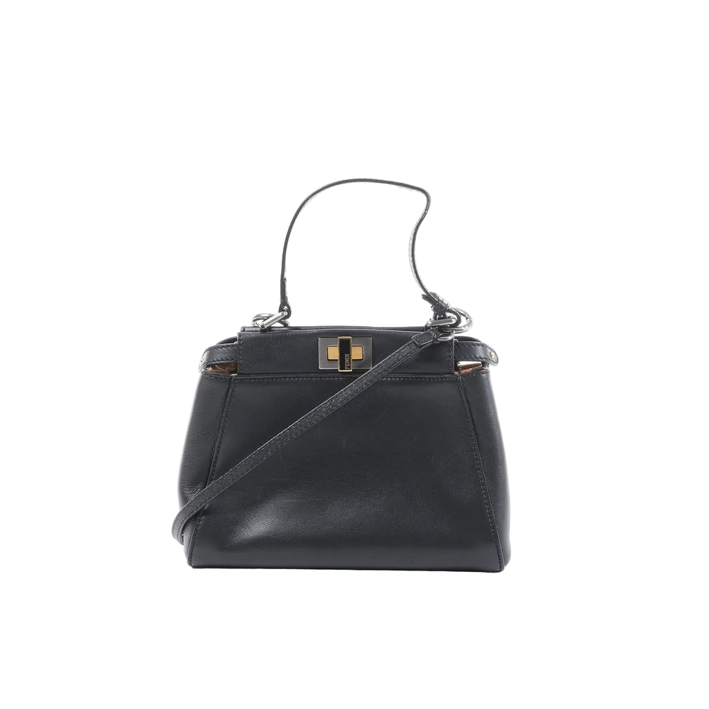 Black Fendi Peekaboo Mini leather handbag with top handle, detachable shoulder strap, and gold-tone twist-lock hardware, front view on a white background.