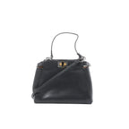 Black Fendi Peekaboo Mini leather handbag with top handle, detachable shoulder strap, and gold-tone twist-lock hardware, front view on a white background.