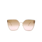Front view of oversized cat-eye sunglasses with gold-tone metal frame and gradient brown-to-pink lenses on a white background.