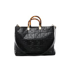 Front view of Fendi Sunshine Medium black leather tote with a raised FF pattern, tortoiseshell-effect top handles, gold-tone fittings and shoulder strap.