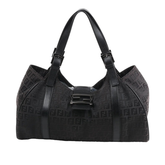 Front view of the FENDI Zucchino Canvas x Leather Handbag 8BR091 in brown, showcasing allover FF monogram canvas, black leather trim and shoulder straps with buckle accents, and a flap closure with black enamel FF buckle, displayed against a white background.