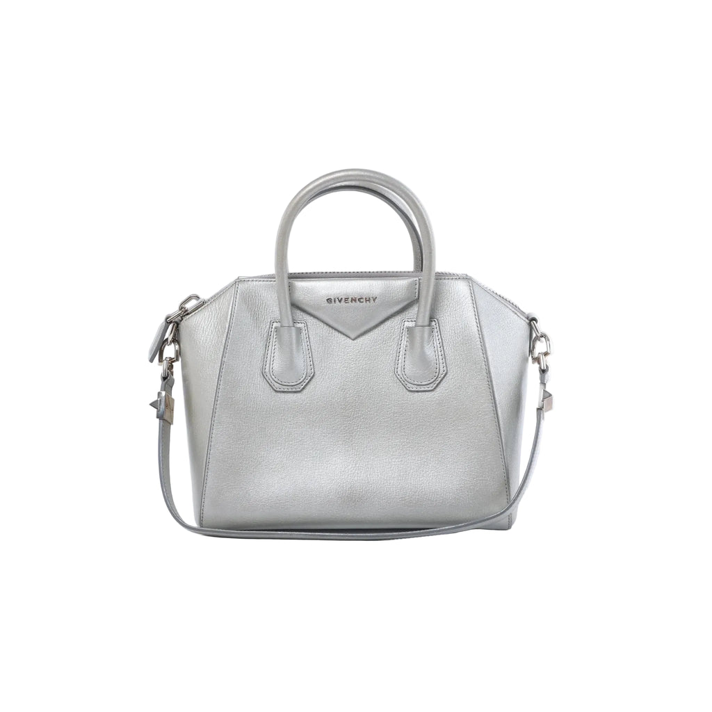 Front view of a silver Givenchy Antigona leather handbag with dual top handles, logo detail, zip closure and shoulder strap.