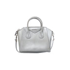 Front view of a silver Givenchy Antigona leather handbag with dual top handles, logo detail, zip closure and shoulder strap.