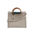 Beige Gucci Bamboo Diana leather handbag with bamboo top handles, green and red handle bands, gold-tone hardware and a detachable shoulder strap.