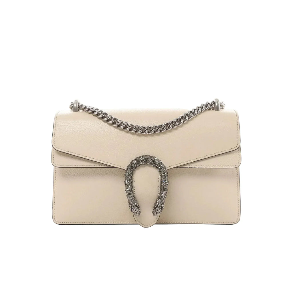 Gucci Dionysus small beige leather crossbody bag with silver-tone chain strap and crystal-embellished horseshoe closure on white background.