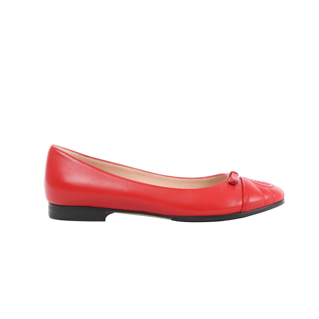 Side view of a red Gucci GG Marmont leather ballet flat with a rounded toe, small red bow, tonal toe detailing and a low black heel.