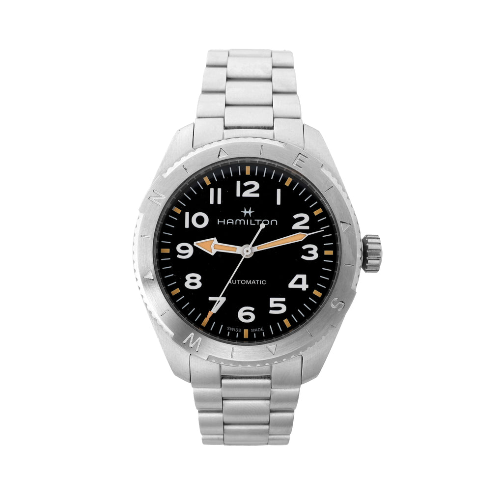 Hamilton Khaki Field H703150 automatic watch with black dial, white Arabic numerals, orange-accented hands, stainless steel case, compass-style bezel, and stainless steel bracelet on a white background.