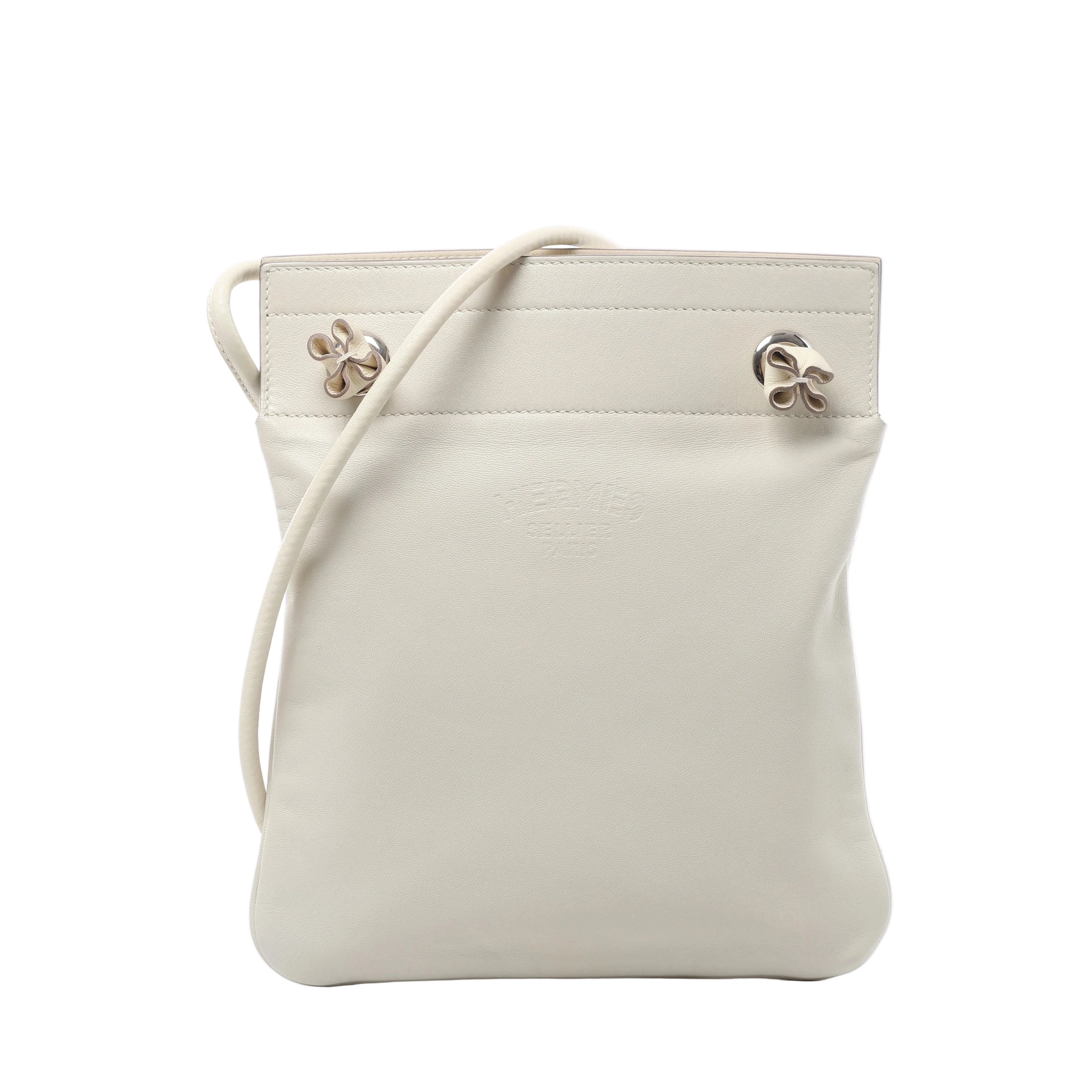 Hermès Aline Mini leather crossbody bag with slim shoulder strap, softly structured pouch shape and silver-tone hardware on a white background.