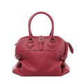 Front view of a rose-pink Hermès Atlas handbag with grained leather, twin rolled handles, a central buckle strap and silver-tone side buckles.