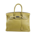 Front view of a Hermès Birkin 35 handbag in Anise Green Taurillon Clemence leather, featuring dual rolled handles, palladium hardware, and a signature flap with turn-lock closure.