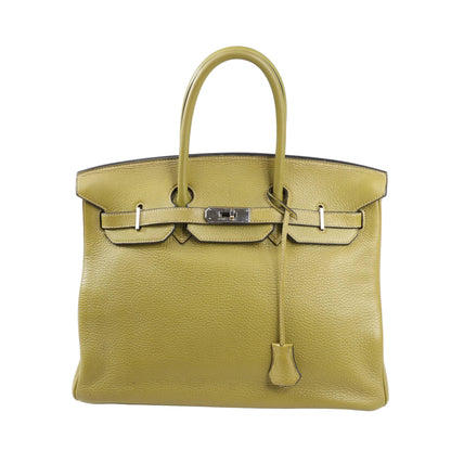 Front view of a Hermès Birkin 35 handbag in Anise Green Taurillon Clemence leather, featuring dual rolled handles, palladium hardware, and a signature flap with turn-lock closure.