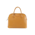 Hermès Bolide 35 natural brown leather handbag with top zip closure, double top handles, oval front patch detail, and silver-tone hardware on white background