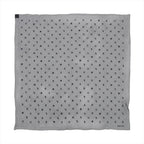 Hermès Carré 100 black silk scarf with repeating small charm motifs in dark tones across the surface and Hermès Paris signature in the corner.