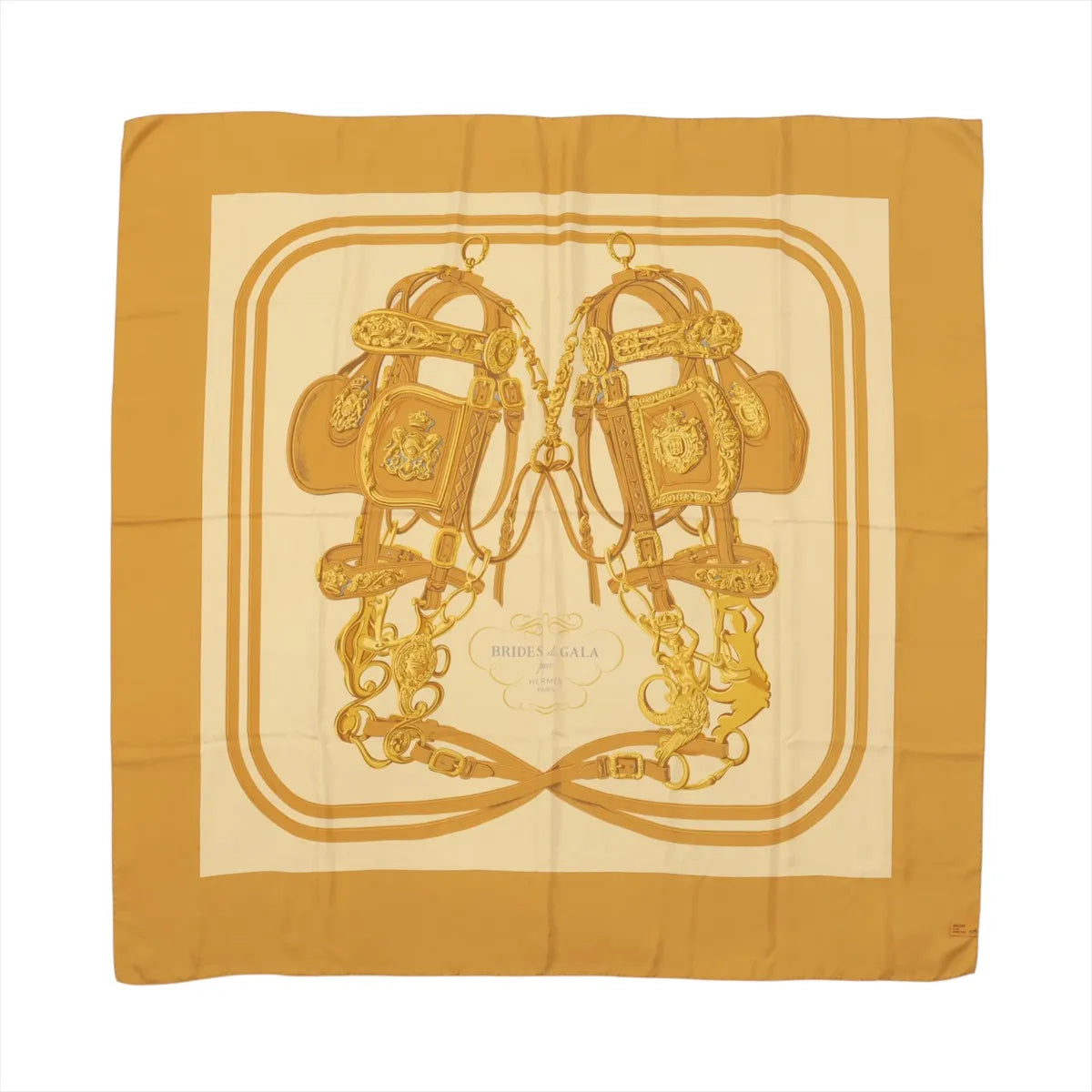 Hermès Carré 140 “Brides de Gala” silk scarf in brown tones with large central bridle and tack illustration on a cream ground and brown border.