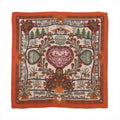 Orange Hermès Carré 140 cashmere-silk scarf laid flat with intricate multicolor folkloric motifs, floral and animal details, and a wide orange border on a white background.