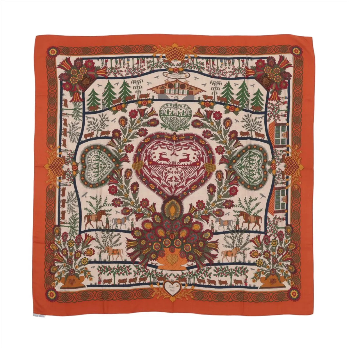 Orange Hermès Carré 140 cashmere-silk scarf laid flat with intricate multicolor folkloric motifs, floral and animal details, and a wide orange border on a white background.