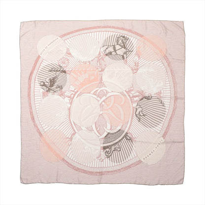 Hermès Carré 90 "Suite et Poursuite" silk handkerchief in pink, showcasing a delicate design of overlapping circles, horses, and ornamental motifs in soft blush, white, and taupe tones, laid flat against a white background.