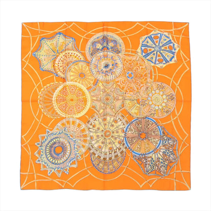 Hermès Carré 90 "LES DÔMES CÉLESTES" silk scarf in bright orange featuring detailed circular dome illustrations in blue, gold, and earth tones, arranged in a celestial-inspired layout.
