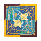 Hermès Carré 140 silk scarf in blue and brown with yellow border and gold equestrian hardware and strap motif, laid flat