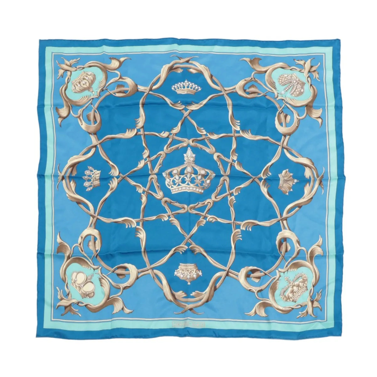 Hermès Carré 70 blue silk scarf with crown motif, ornate tan scrollwork pattern, and light blue border, laid flat