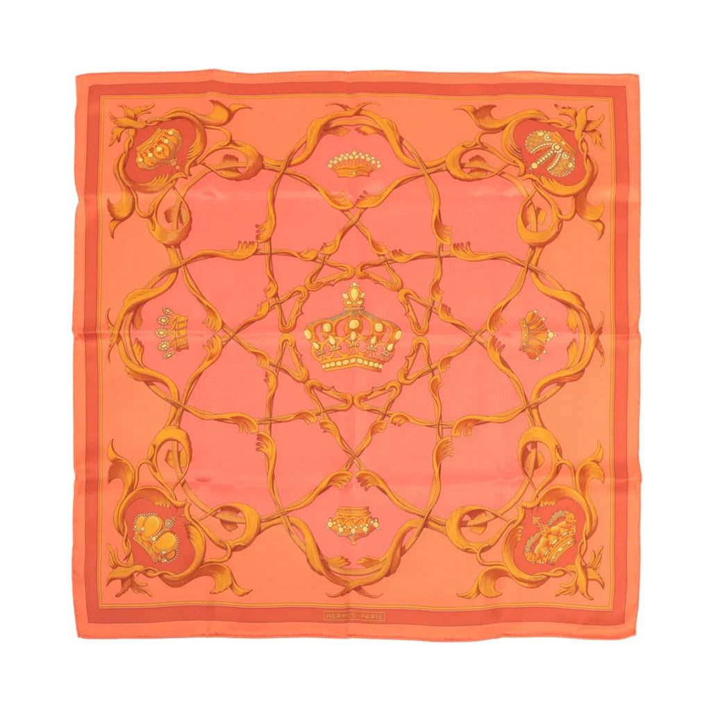 Hermès Carré 70 orange silk scarf with gold crown motif, ornate scrollwork border, and “Hermès Paris” text at bottom on white background