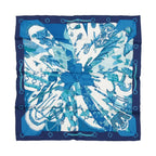 Hermès Carré 70 “Soleil de Soie” silk scarf in blue with navy border, blue sunburst-style panels, and central bow motif.