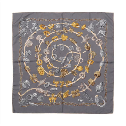 Hermès Carré 90 "Alliances du Monde" silk scarf in gray featuring a spiral pattern of detailed gold and silver rings, symbolizing global unity and cultural heritage, framed by an elegant rope border.